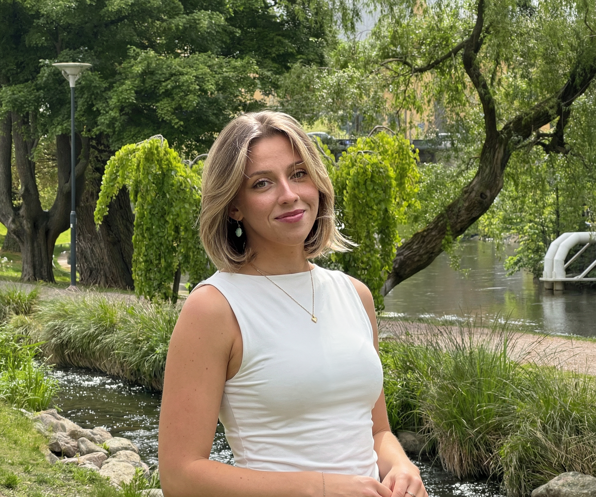 En porträttbild av Mikaela Vanky i grönskande miljö